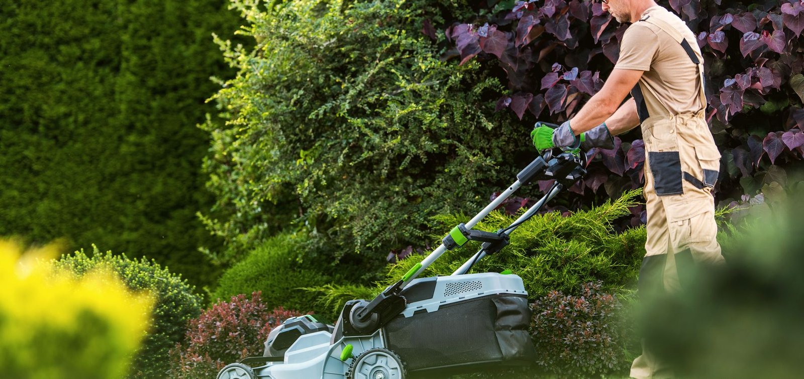 Lawn care professional mowing a garden
