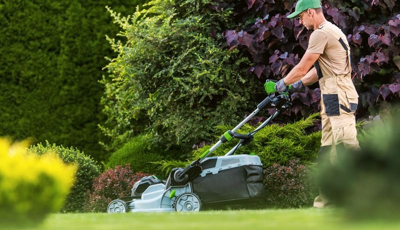 Lawn care professional mowing a garden